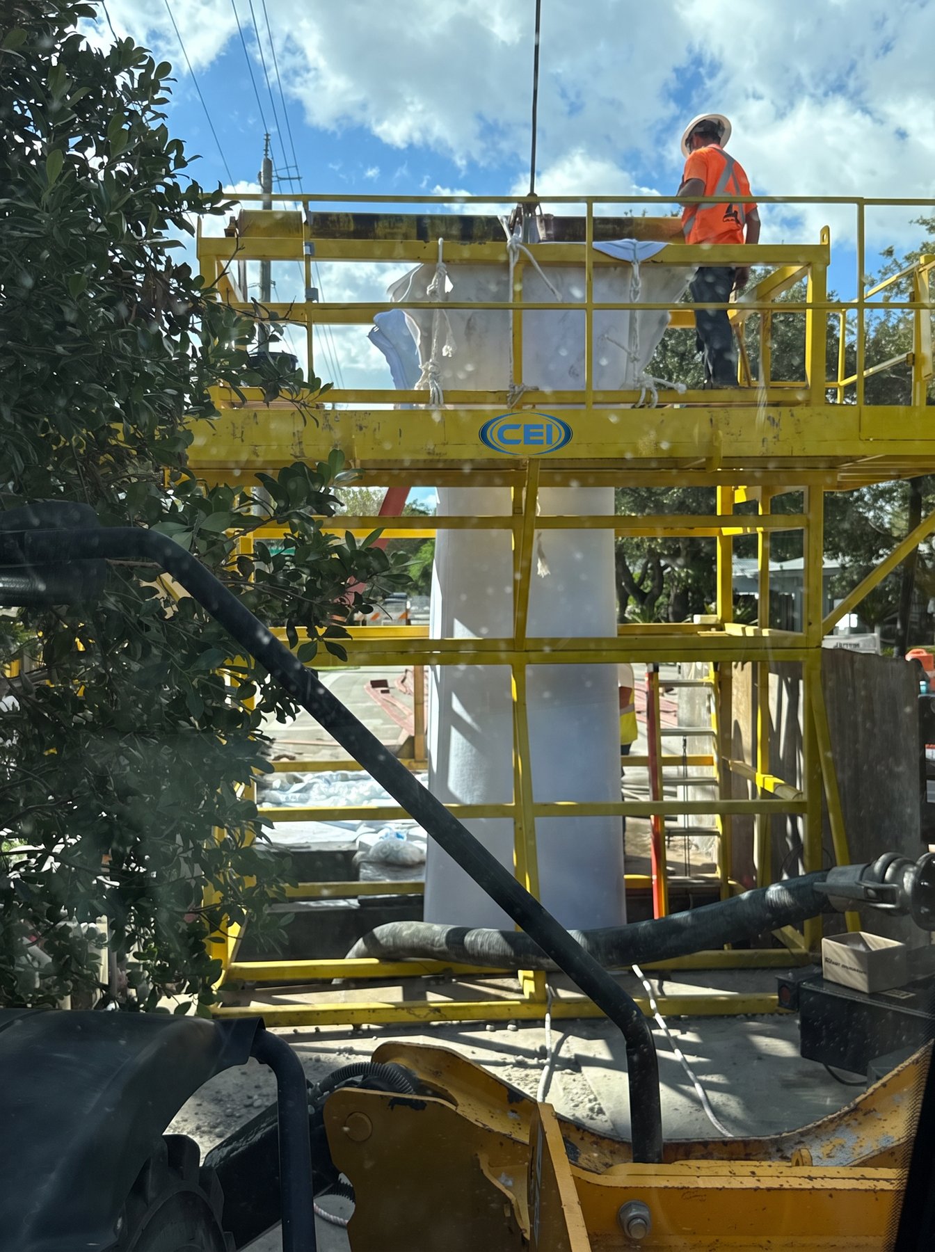 CEI-branded inversion tower with a crew member on the top deck installing a wet-out CIPP liner on an active Florida jobsite